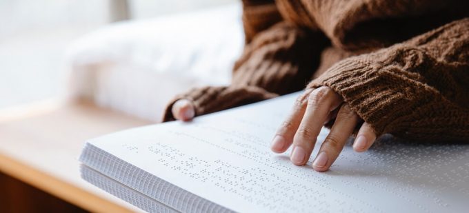 a blind person reading a braille book