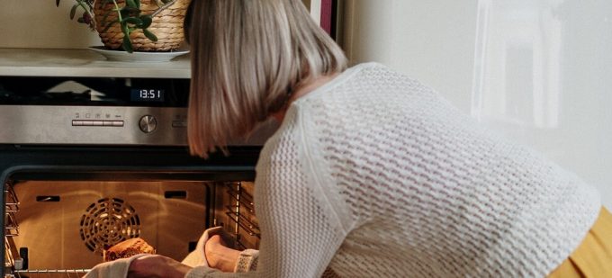 elderly woman cooking with an oven